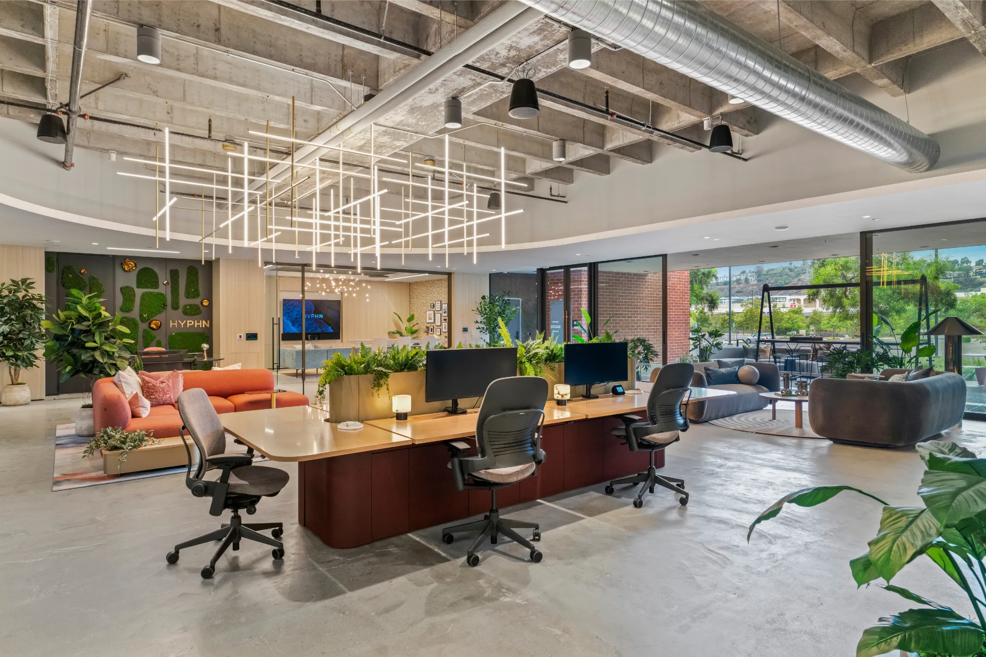 The HYPHN studio — moss-wall logo, open plan, natural light